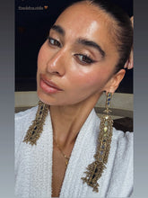 Load image into Gallery viewer, Model with slicked-back hair and a white shirt wearing the long Gold Deco Maxi Earrings
